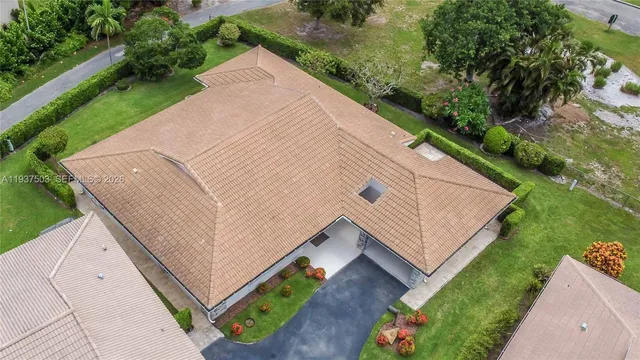 an aerial view of residential houses with outdoor space and trees