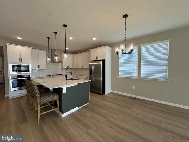 a kitchen that has a sink a stove and cabinets