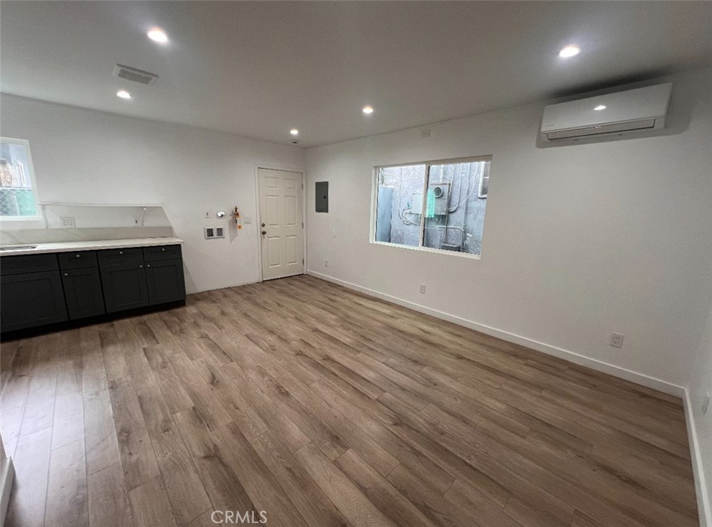 1207 East 23rd Street, Unit 1/2 Los Angeles, CA 90011 - Photo 2 of 8 an empty room with wooden floor and windows