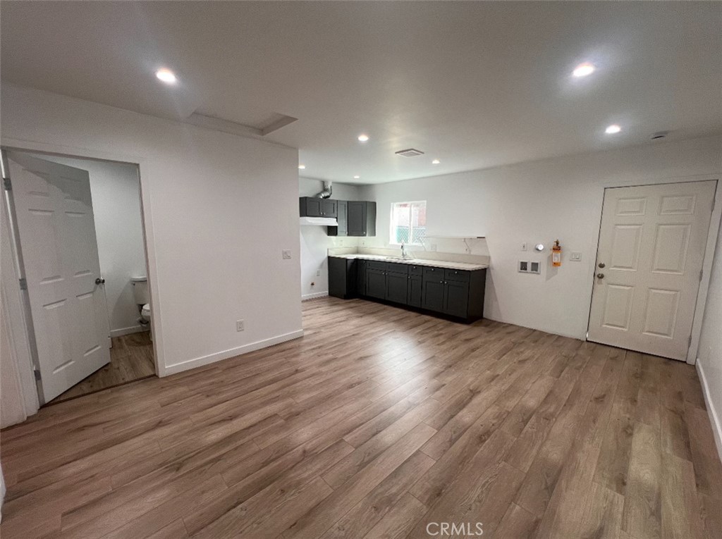 1207 East 23rd Street, Unit 1/2 Los Angeles, CA 90011 - Photo 3 of 8 an empty room with wooden floor and window
