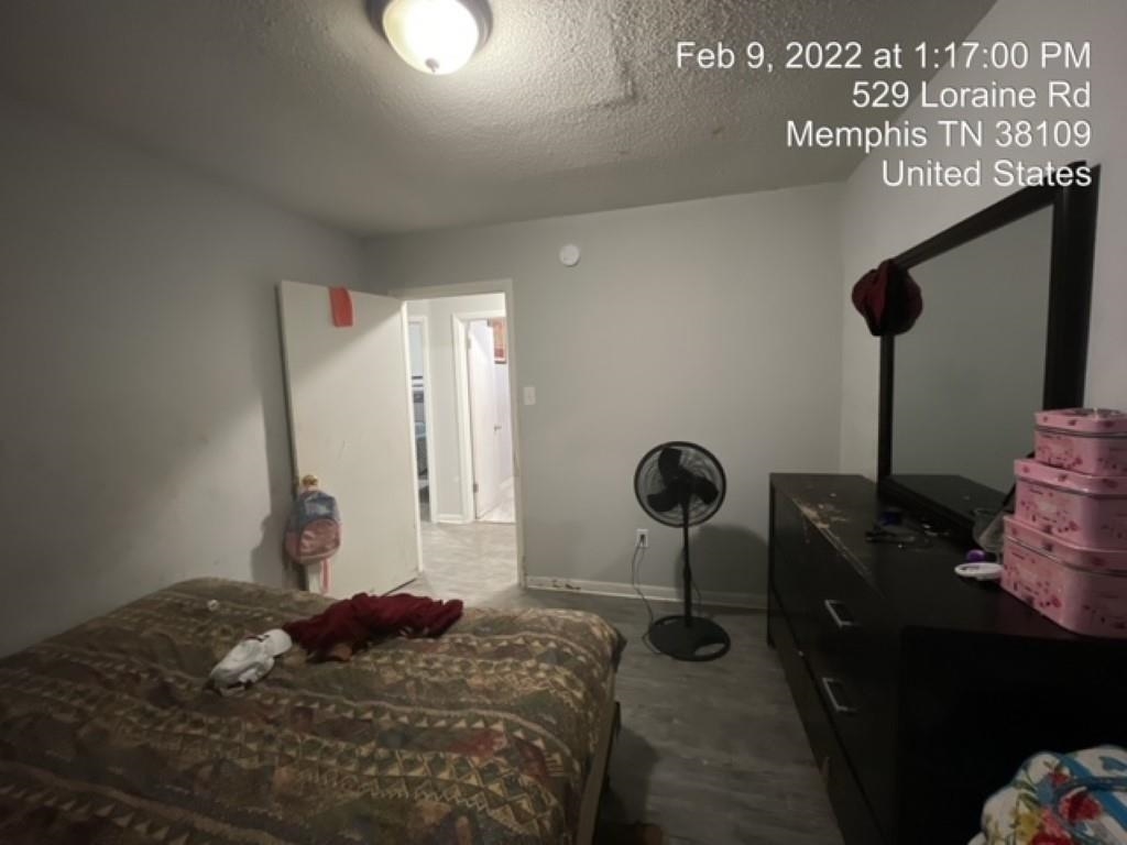 529 Loraine Road Memphis, TN 38109 - Photo 13 of 20 a bedroom with a bed and a chandelier