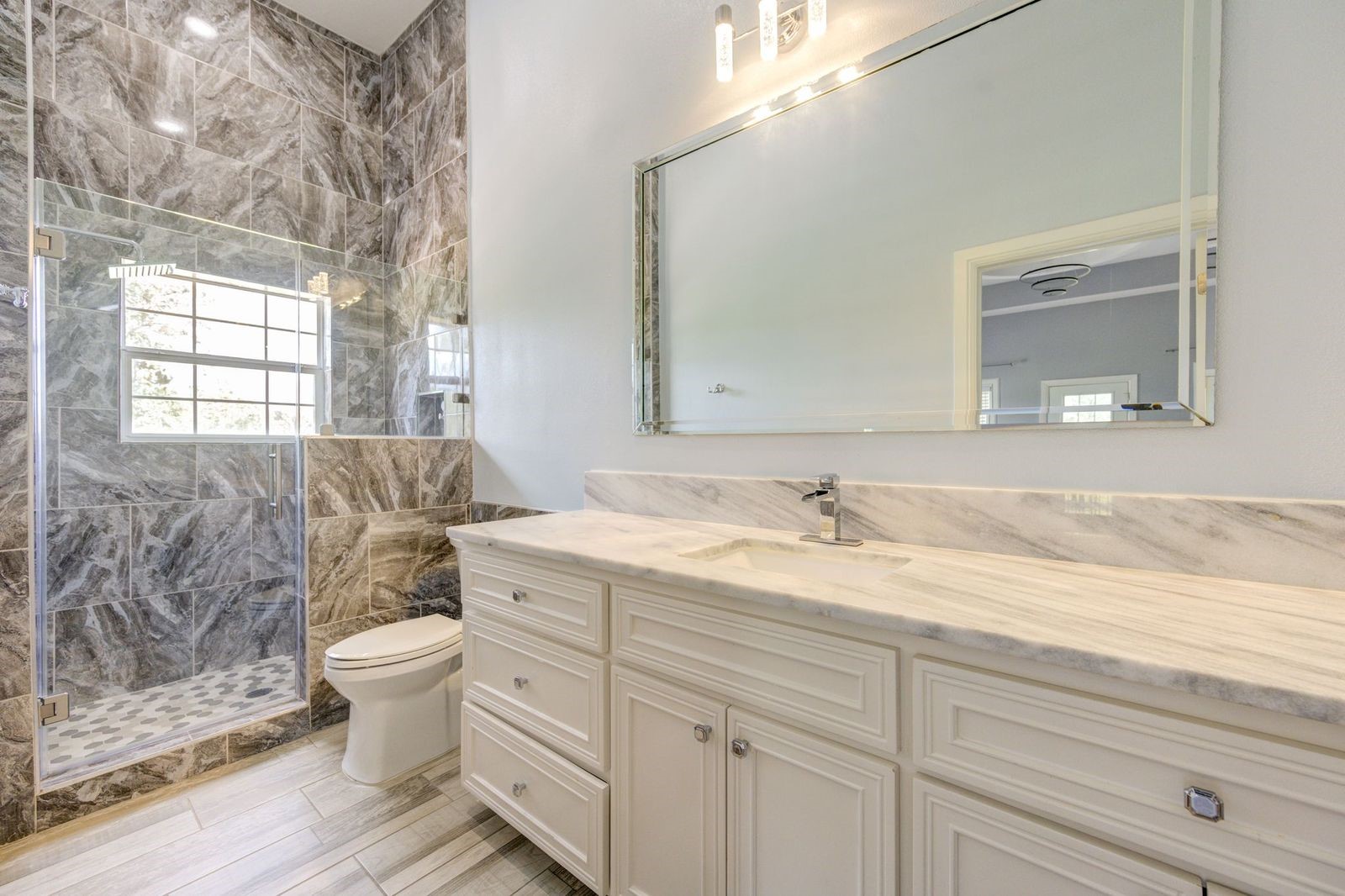 21038 Angus Drive Cleveland, TX 77328 - Photo 38 of 49 a bathroom with a granite countertop toilet sink and mirror