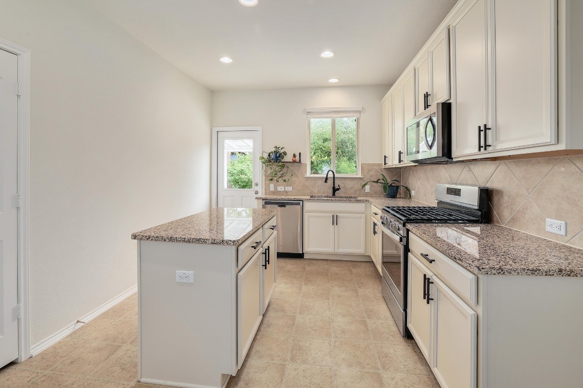 1924 Cliffbrake Way Georgetown, TX 78626 - Photo 12 of 27 a kitchen with stainless steel appliances granite countertop a sink stove and cabinets