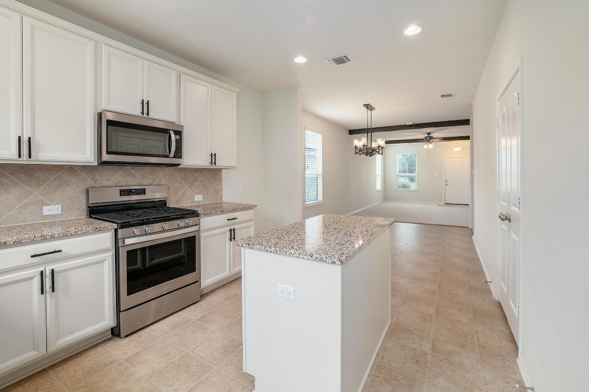 1924 Cliffbrake Way Georgetown, TX 78626 - Photo 14 of 27 a kitchen with granite countertop a sink stainless steel appliances and white cabinets