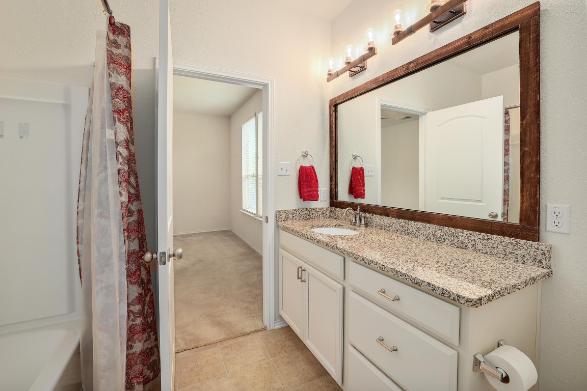 1924 Cliffbrake Way Georgetown, TX 78626 - Photo 17 of 27 a bathroom with a granite countertop sink and a mirror