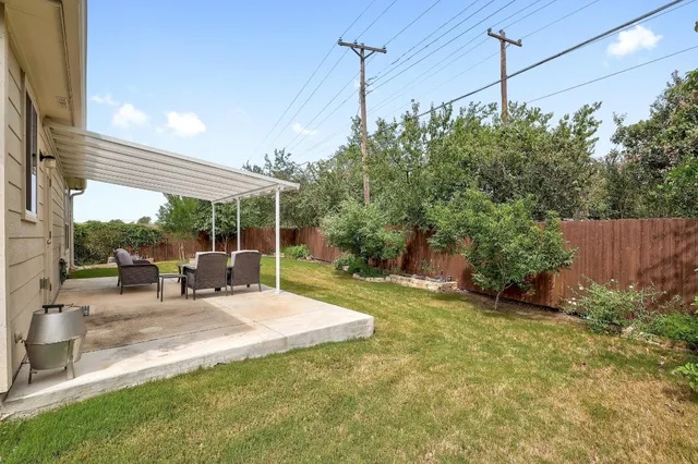 a view of a backyard with sitting area and garden