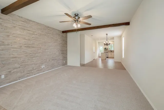 a view of a hallway with a chandelier fan and windows