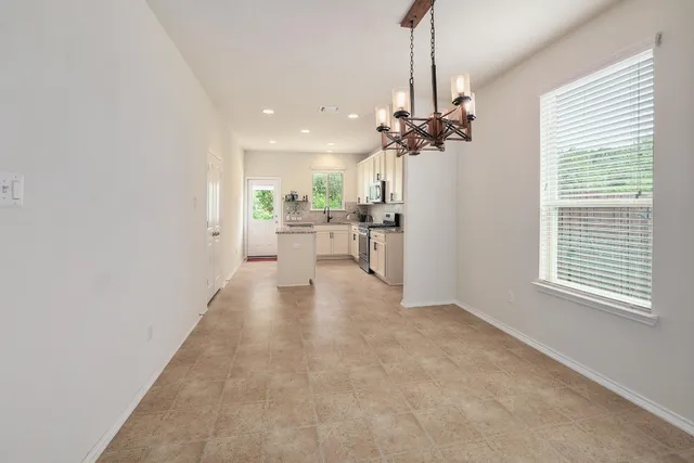 a view of a livingroom with a chandelier furniture and windows