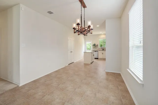 a view of a room with a chandelier fan and windows