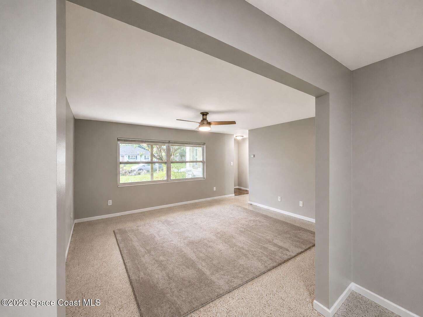 987 Kings Post Road Rockledge, FL 32955 - Photo 25 of 30 an empty room with windows and ceiling fan