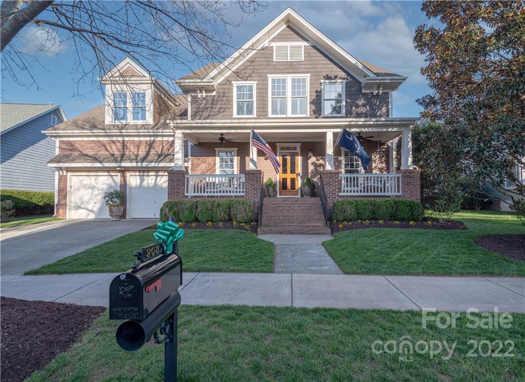 a front view of a house with garden and trees