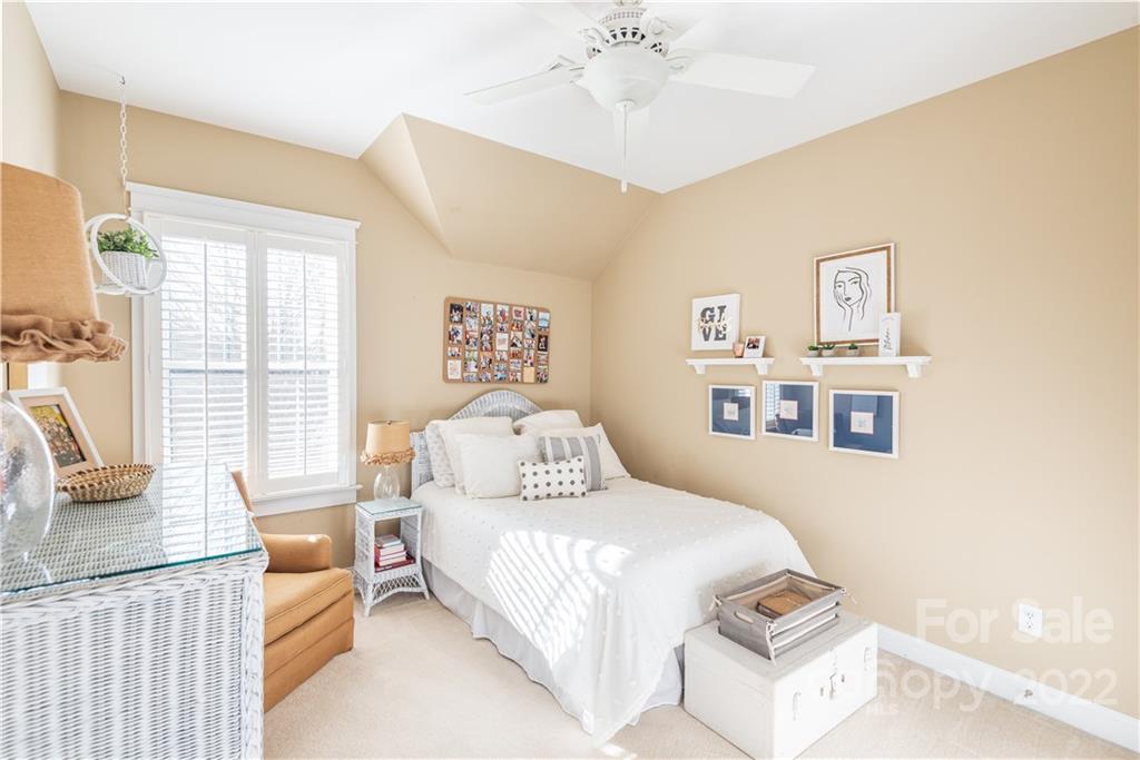 908 Gardenia Street Fort Mill, SC 29708 - Photo 24 of 39 a bedroom with a large bed and a chandelier