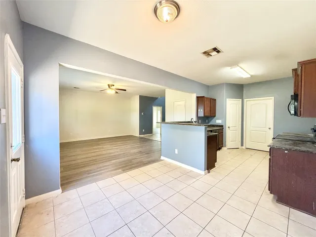 a view of a kitchen with kitchen island granite countertop wooden cabinets and a counter top space