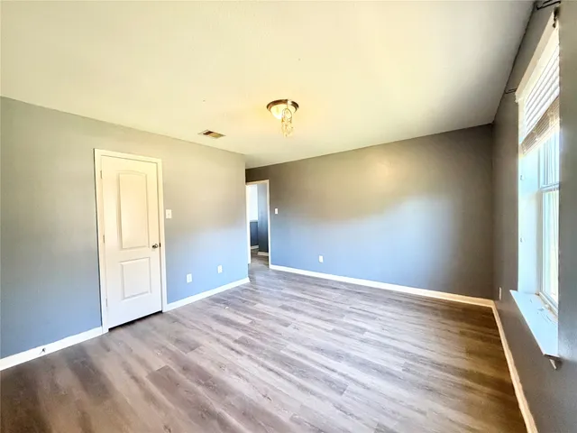 a view of an empty room with glass door and a window