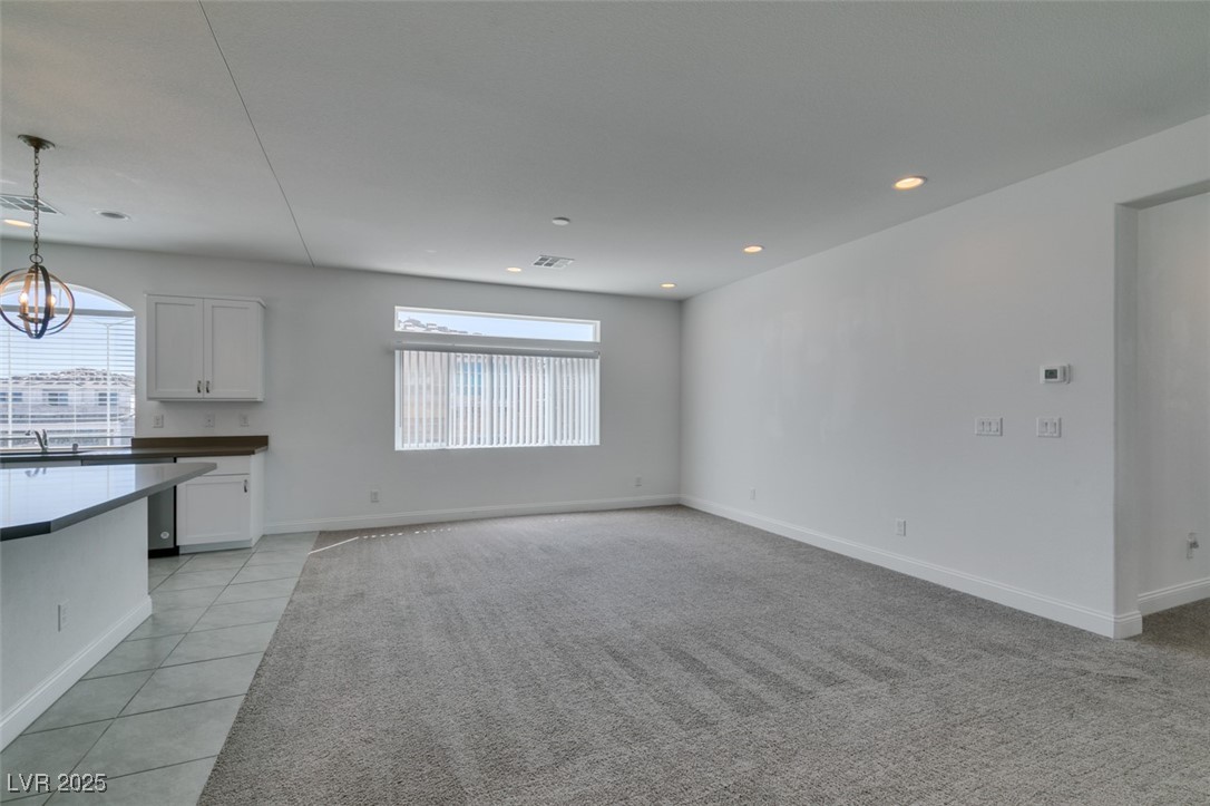 6335 Rock Strm Lane Las Vegas, NV 89141 - Photo 29 of 61 Unfurnished living room with healthy amount of natural light, recessed lighting, light tile patterned floors, and light carpet