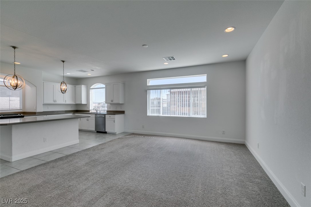 6335 Rock Strm Lane Las Vegas, NV 89141 - Photo 31 of 61 Unfurnished living room featuring recessed lighting, light colored carpet, light tile patterned flooring, and a chandelier