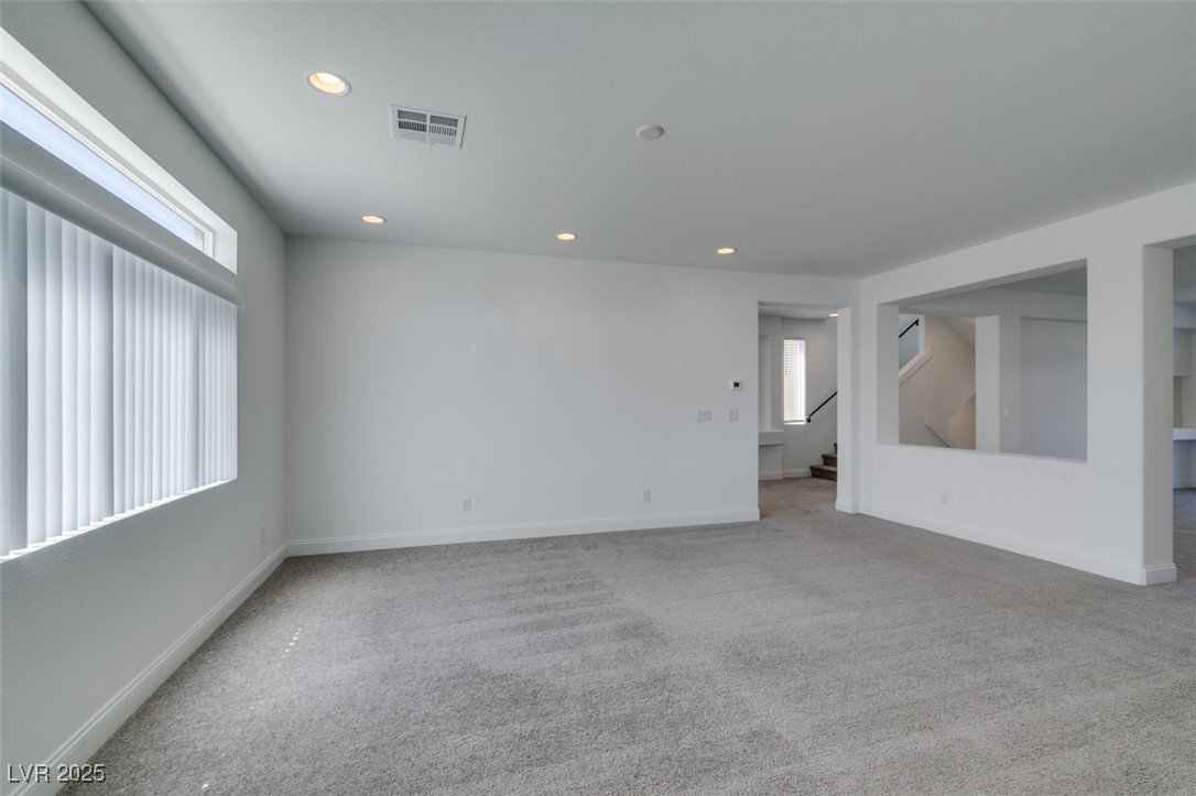 6335 Rock Strm Lane Las Vegas, NV 89141 - Photo 32 of 61 Empty room with light colored carpet, recessed lighting, and stairway