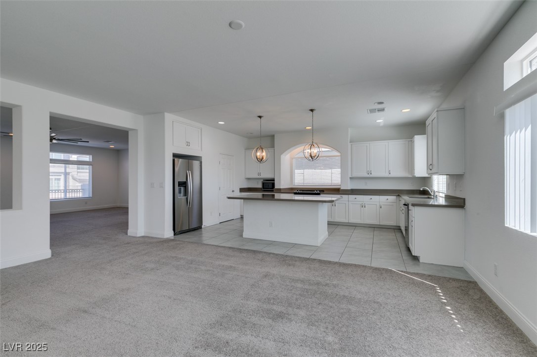 6335 Rock Strm Lane Las Vegas, NV 89141 - Photo 35 of 61 Kitchen featuring white cabinetry, a chandelier, light carpet, decorative light fixtures, and stainless steel fridge