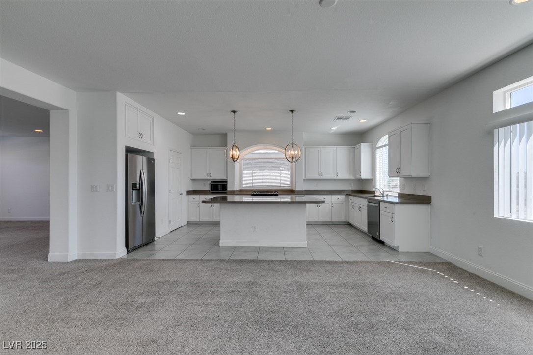 6335 Rock Strm Lane Las Vegas, NV 89141 - Photo 36 of 61 Kitchen with a chandelier, light carpet, stainless steel appliances, white cabinets, and recessed lighting