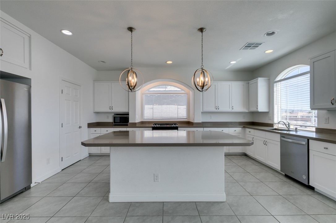 6335 Rock Strm Lane Las Vegas, NV 89141 - Photo 38 of 61 Kitchen with white cabinets, stainless steel appliances, a kitchen island, light tile patterned floors, and recessed lighting
