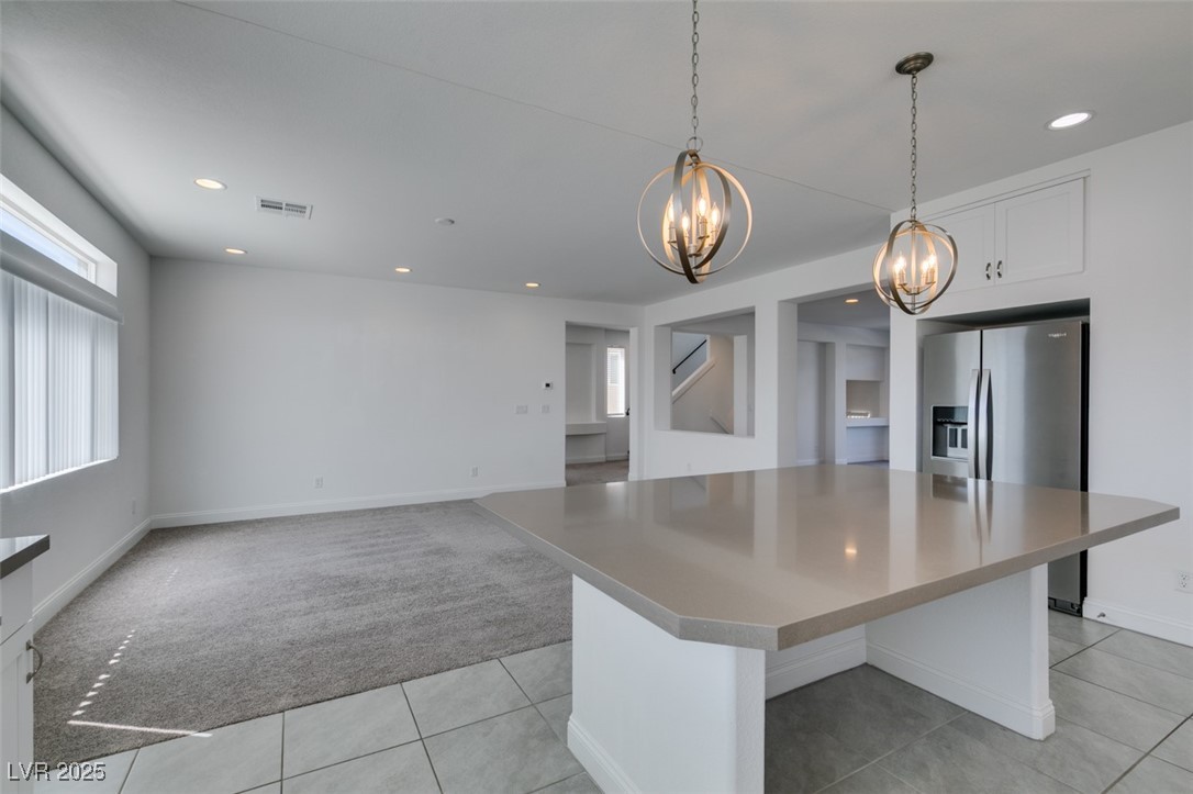 6335 Rock Strm Lane Las Vegas, NV 89141 - Photo 42 of 61 Kitchen featuring recessed lighting, hanging light fixtures, stainless steel refrigerator with ice dispenser, light tile patterned flooring, and white cabinets