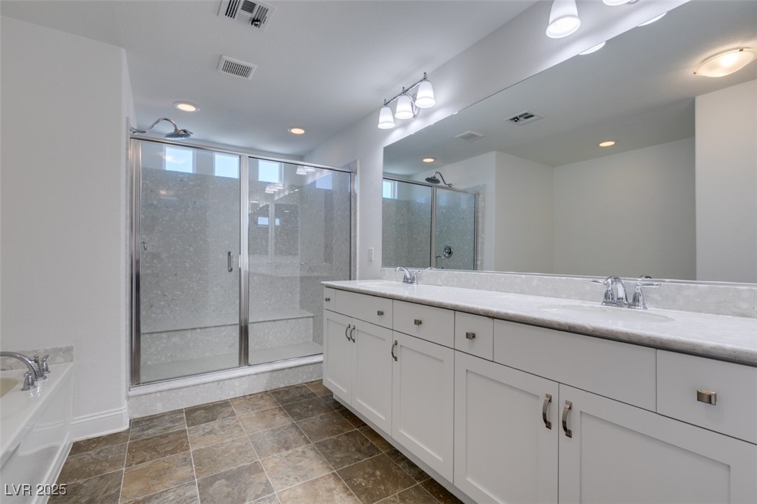 6335 Rock Strm Lane Las Vegas, NV 89141 - Photo 53 of 61 Bathroom featuring a stall shower, double vanity, a garden tub, dark stone finish floors, and recessed lighting