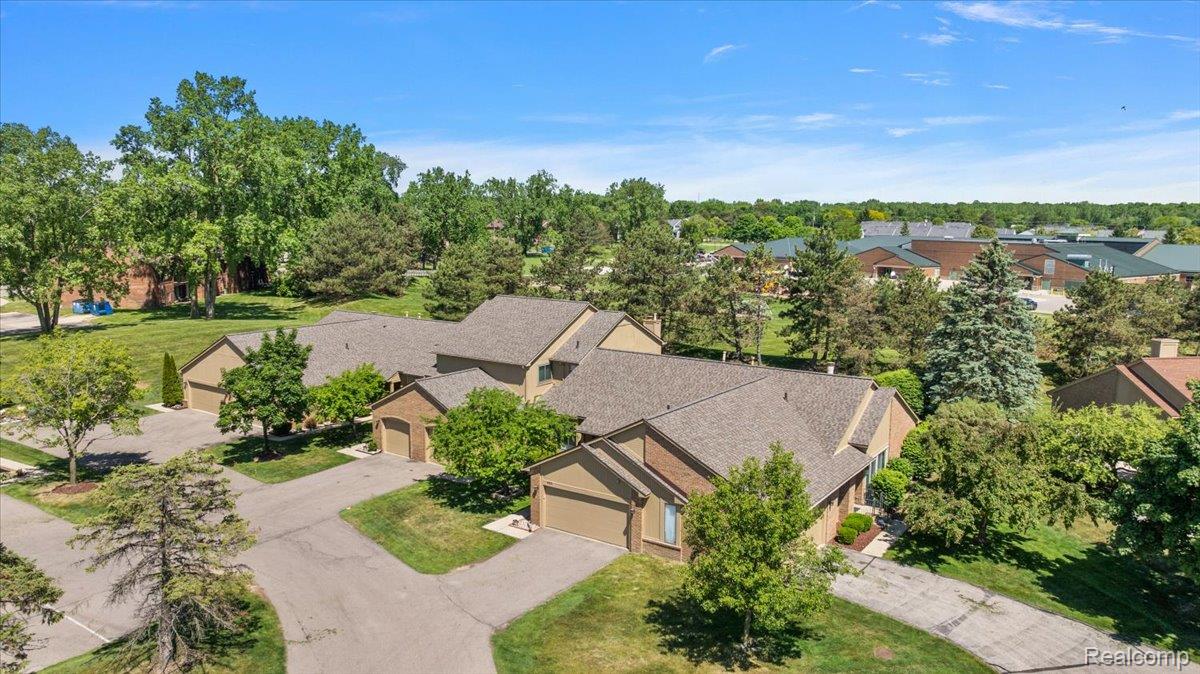 552 Tennyson Rochester, MI 48307 - Photo 34 of 36 Residential community featuring multiple attached homes with individual garages, surrounded by mature trees and manicured lawns
