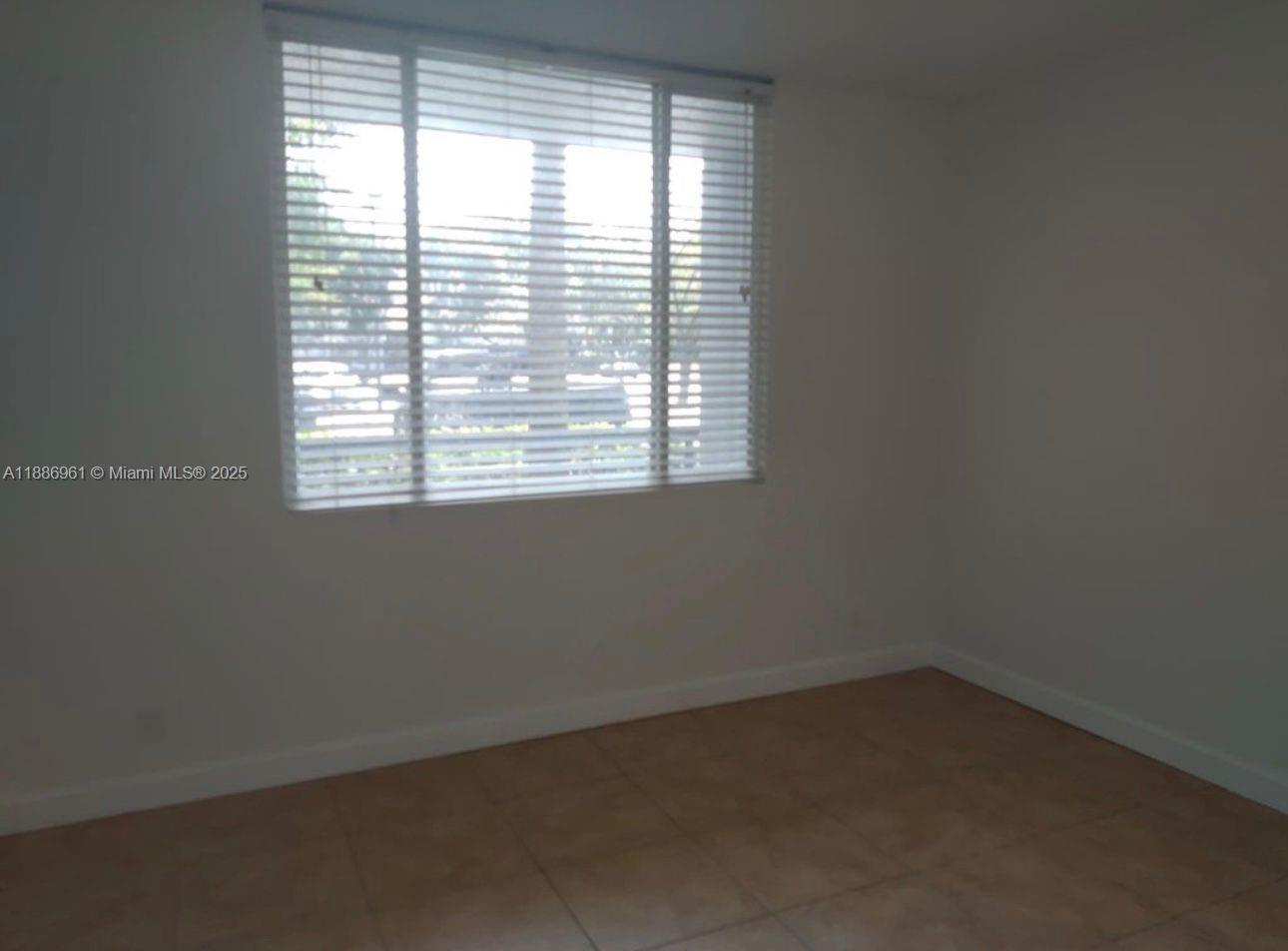 711 Lyons Road, Unit 14107 Coconut Creek, FL 33063 - Photo 13 of 24 an empty room with a window