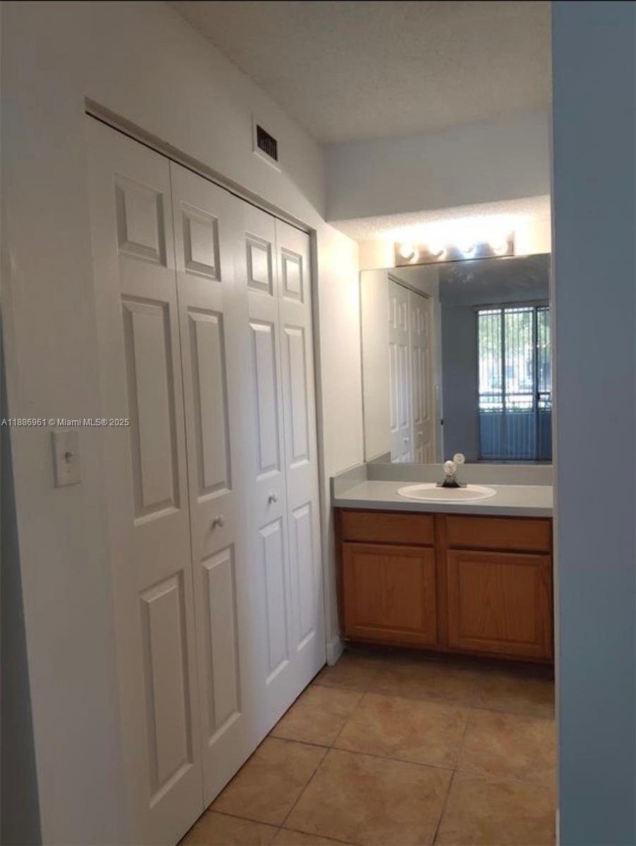 711 Lyons Road, Unit 14107 Coconut Creek, FL 33063 - Photo 15 of 24 a bathroom with a double vanity sink and mirror