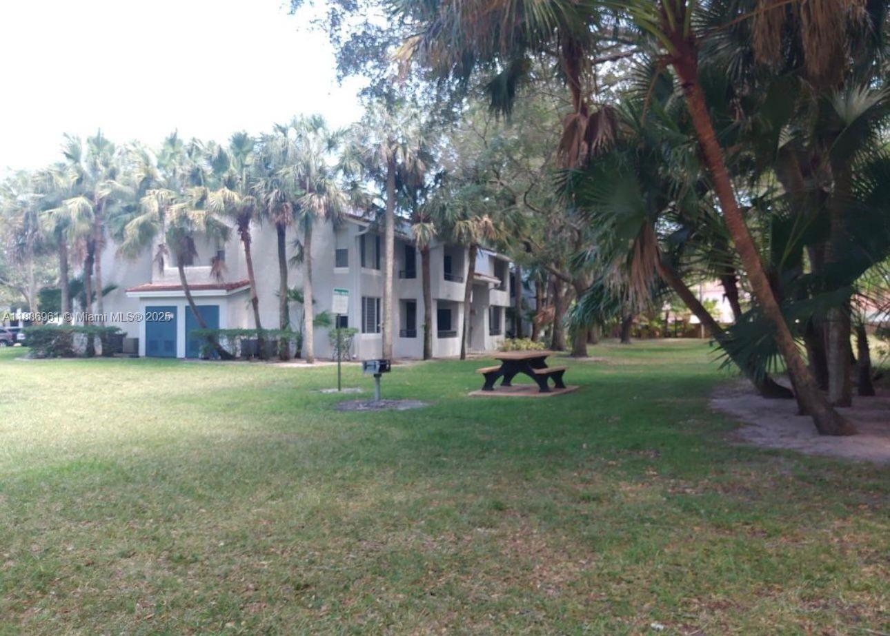 711 Lyons Road, Unit 14107 Coconut Creek, FL 33063 - Photo 17 of 24 a view of a large trees with a house in the background