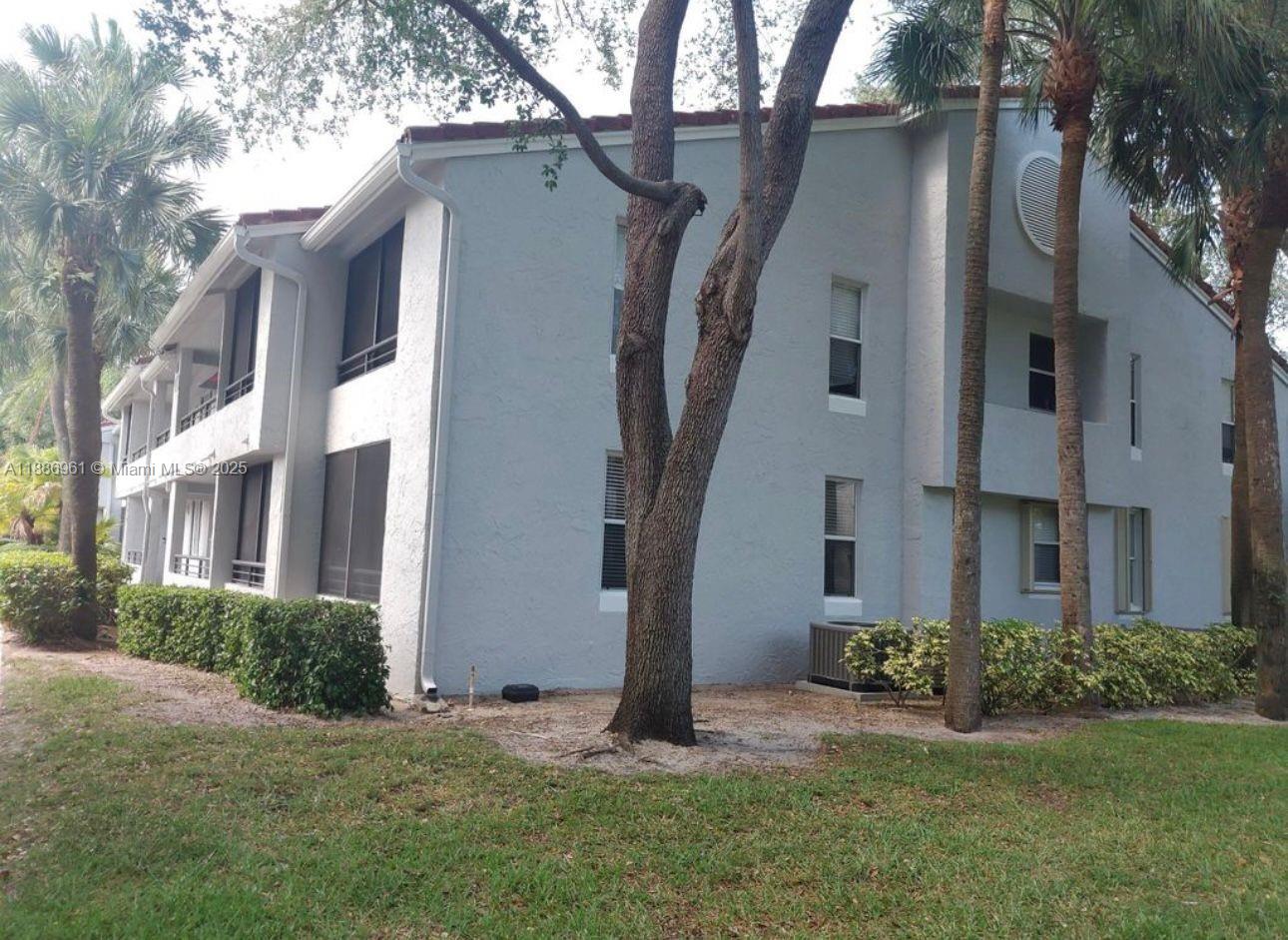 711 Lyons Road, Unit 14107 Coconut Creek, FL 33063 - Photo 18 of 24 a front view of a house with a yard