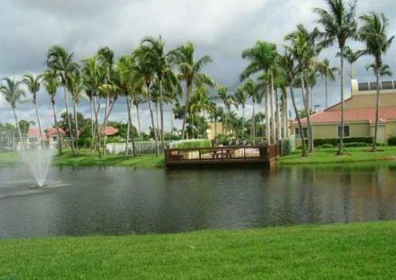 711 Lyons Road, Unit 14107 Coconut Creek, FL 33063 - Photo 23 of 24 a view of a lake with a big yard and palm trees