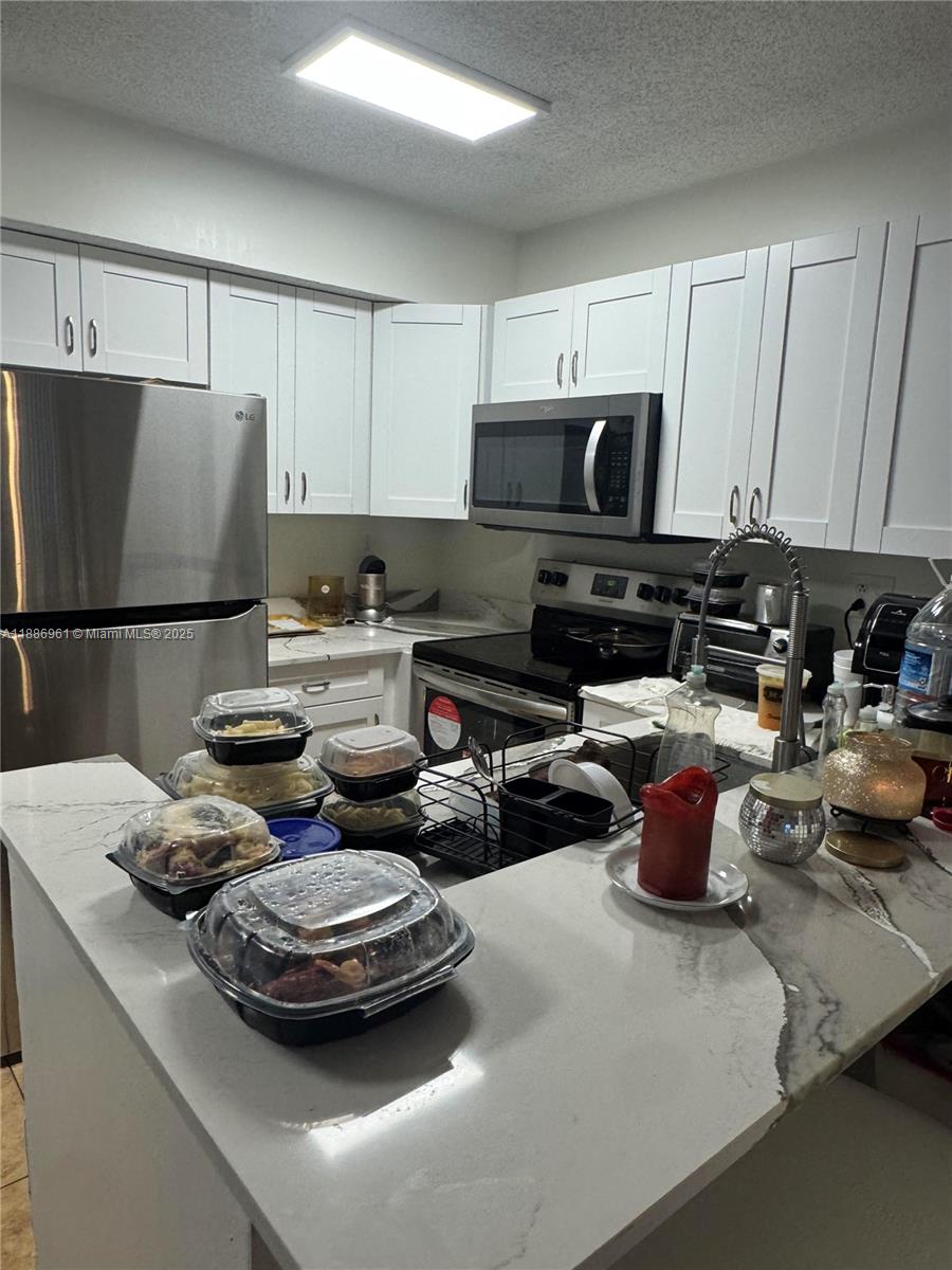 711 Lyons Road, Unit 14107 Coconut Creek, FL 33063 - Photo 6 of 24 a kitchen with a sink appliances and cabinets