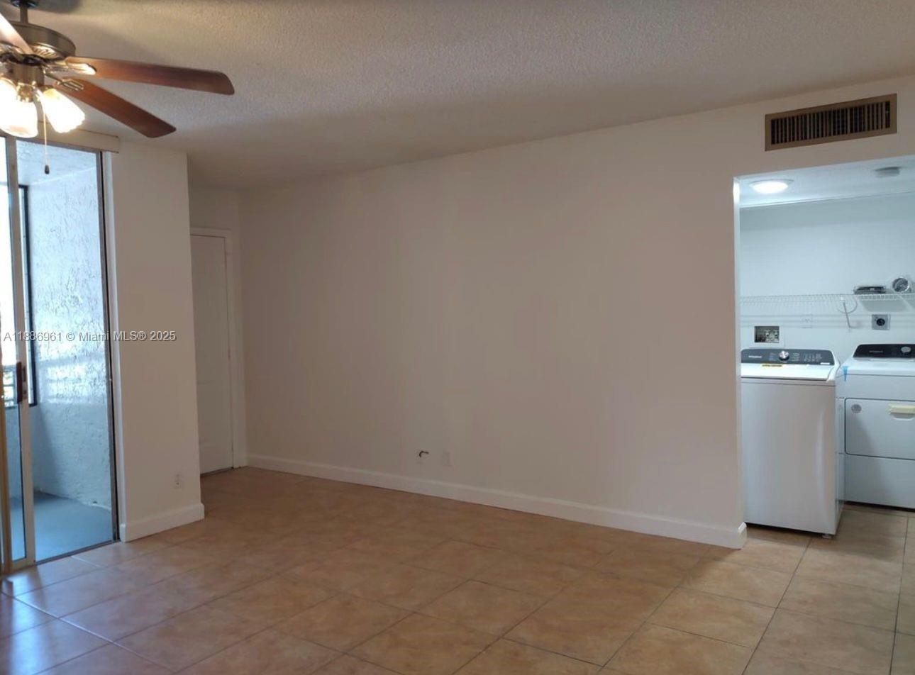 711 Lyons Road, Unit 14107 Coconut Creek, FL 33063 - Photo 8 of 24 a view of a kitchen with a sink and a refrigerator