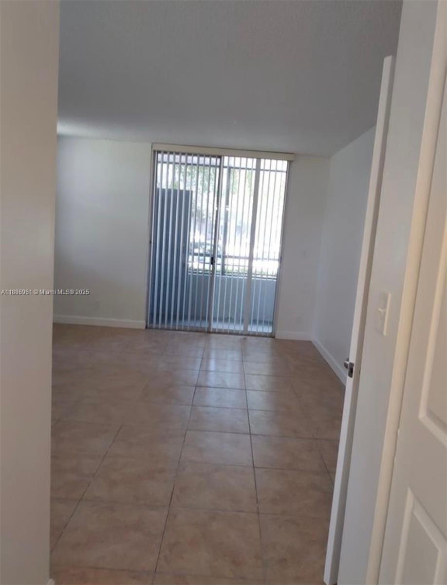 711 Lyons Road, Unit 14107 Coconut Creek, FL 33063 - Photo 9 of 24 a view of an empty room and a window