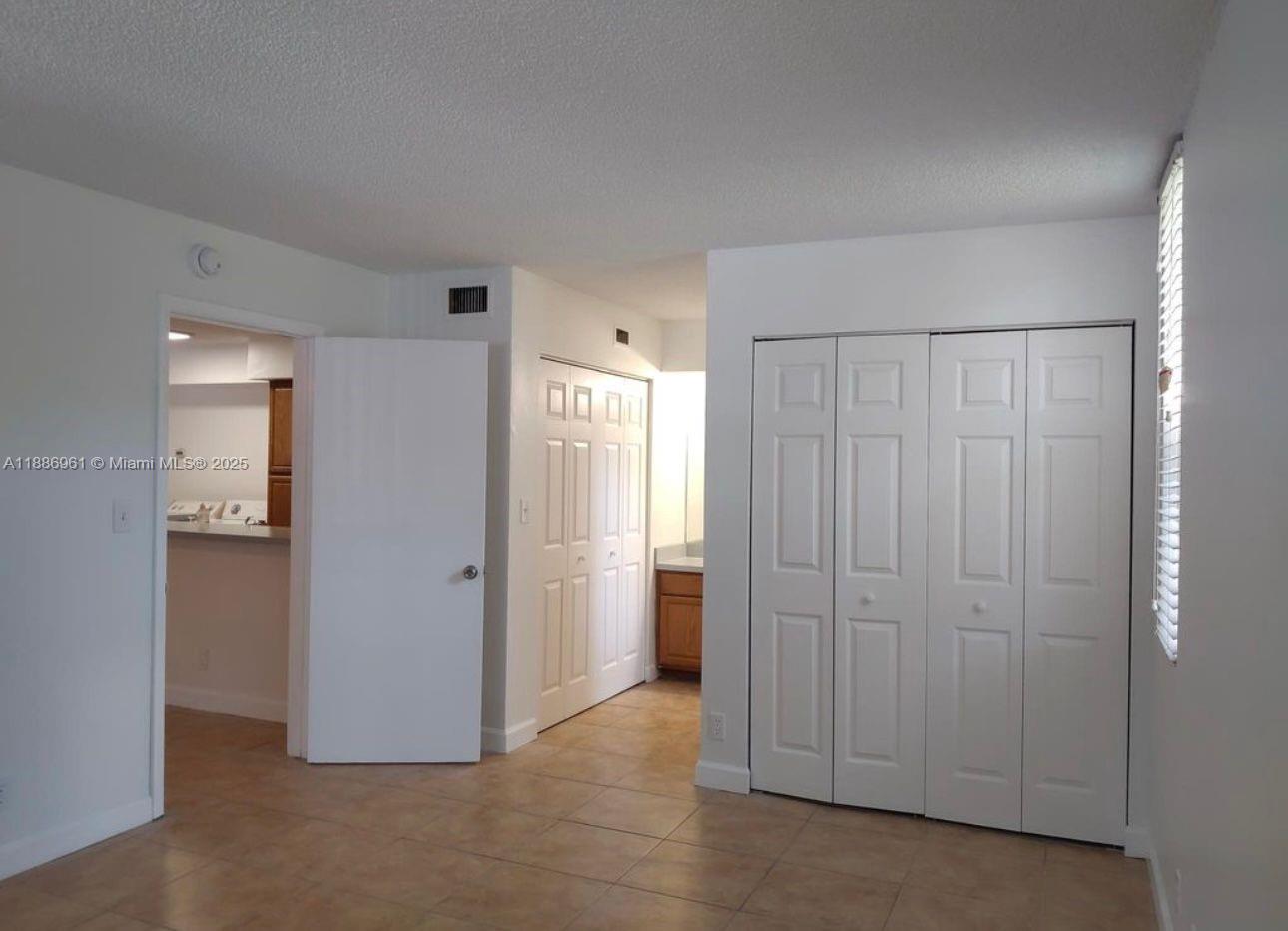 711 Lyons Road, Unit 14107 Coconut Creek, FL 33063 - Photo 10 of 24 a view of a utility room with closet area