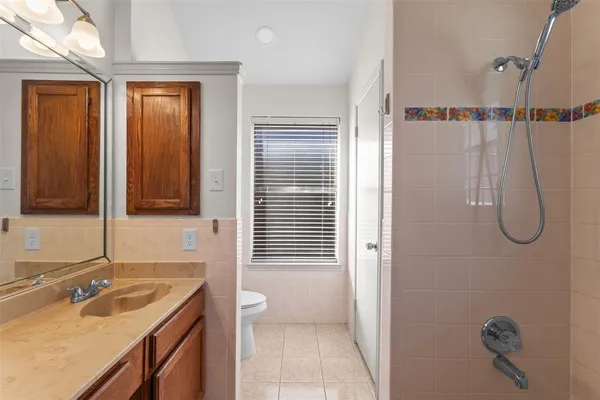 a bathroom with a granite countertop sink a mirror and shower