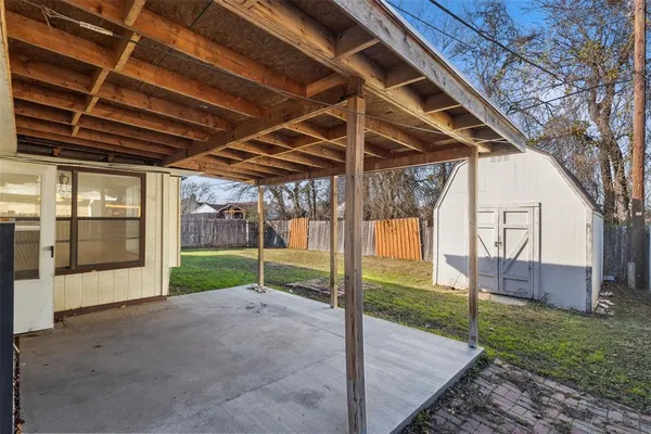 a view of a backyard with wooden floor and iron fence