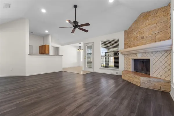 a view of empty room with wooden floor and fireplace