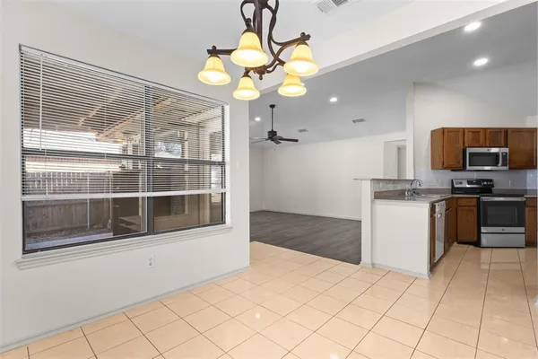 a kitchen with stainless steel appliances granite countertop a stove a microwave and a refrigerator
