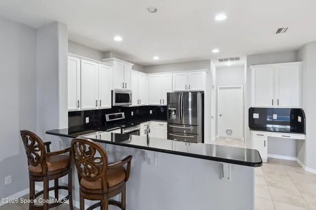 a kitchen that has a sink and stainless steel appliances