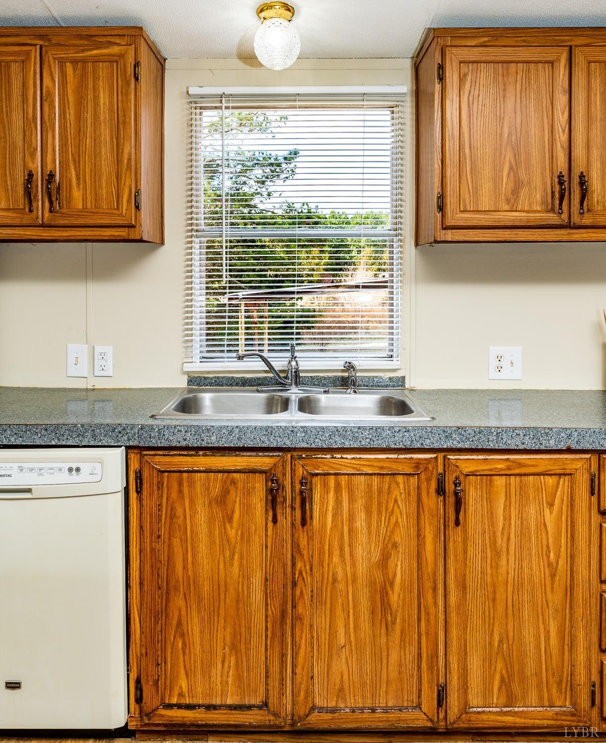 5893 Red House Road Appomattox, VA 24522 - Photo 16 of 28 a kitchen with granite countertop wooden cabinets a sink and a window