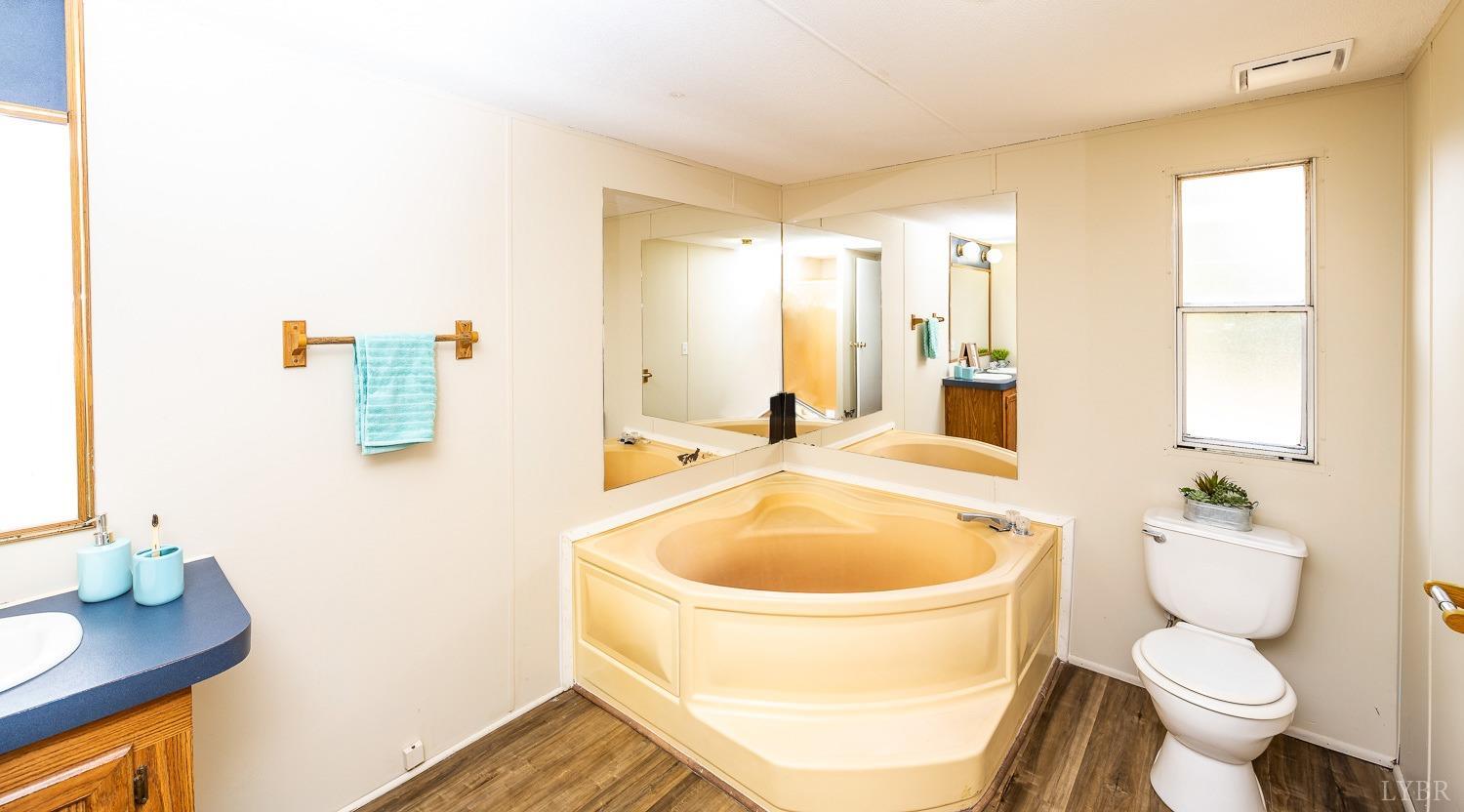 5893 Red House Road Appomattox, VA 24522 - Photo 8 of 28 a bathroom with a toilet sink a mirror and tub