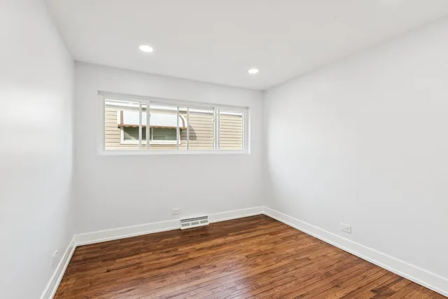 a view of a room with wooden floor and window