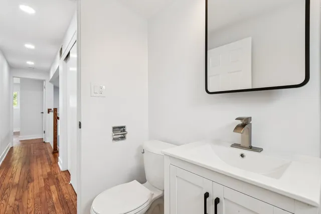 a bathroom with a sink a toilet and mirror