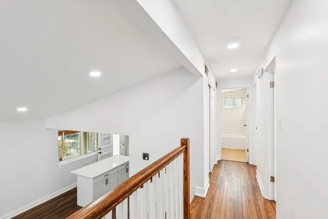 a view of a hallway with wooden floor and stairs