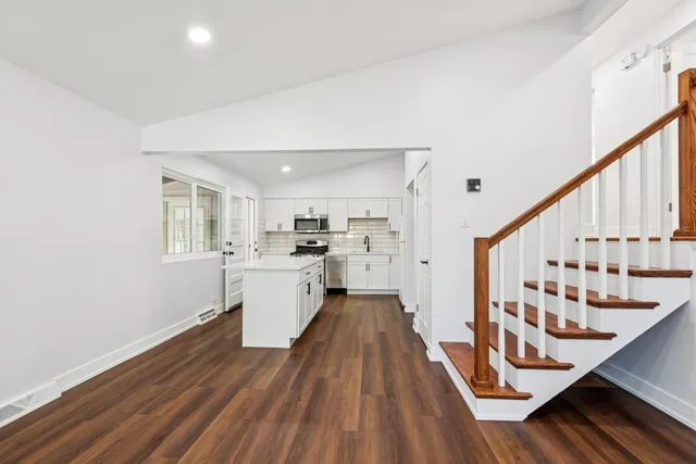 a view of a kitchen with wooden floor and electronic appliances