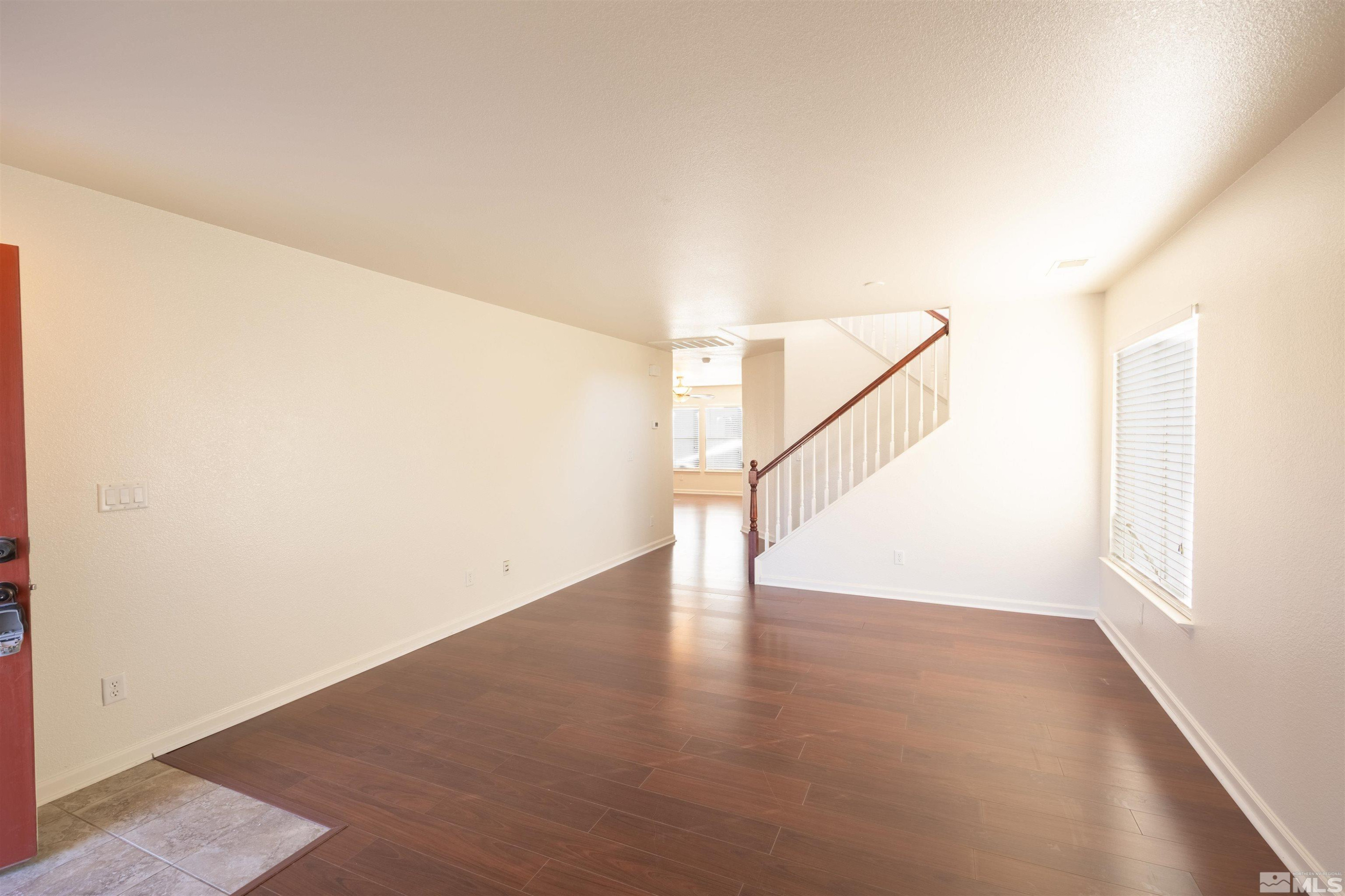 9180 Streagle Way Reno, NV 89506 - Photo 4 of 34 a view of an empty room with wooden floor and a window