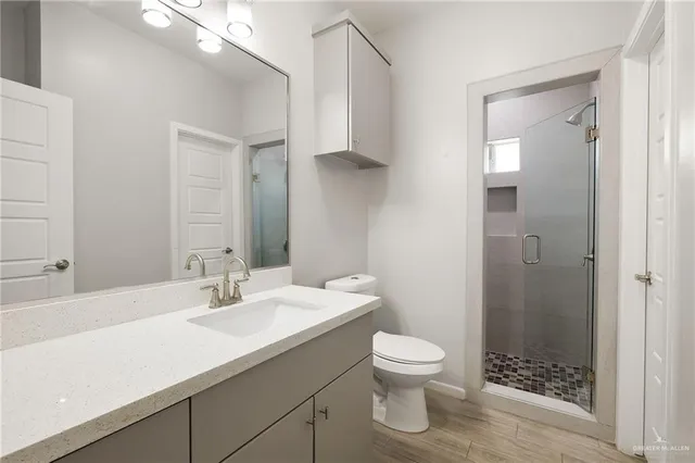 a bathroom with a sink a toilet and shower