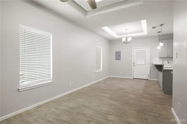 an empty room with windows and a ceiling fan